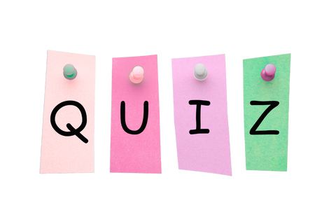 Letters spelling the word quiz on colour pieces of paper and thumb tack pins pinning to an invisible background