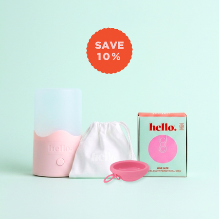 Pink menstrual disc with packaging and discount label on a light green background