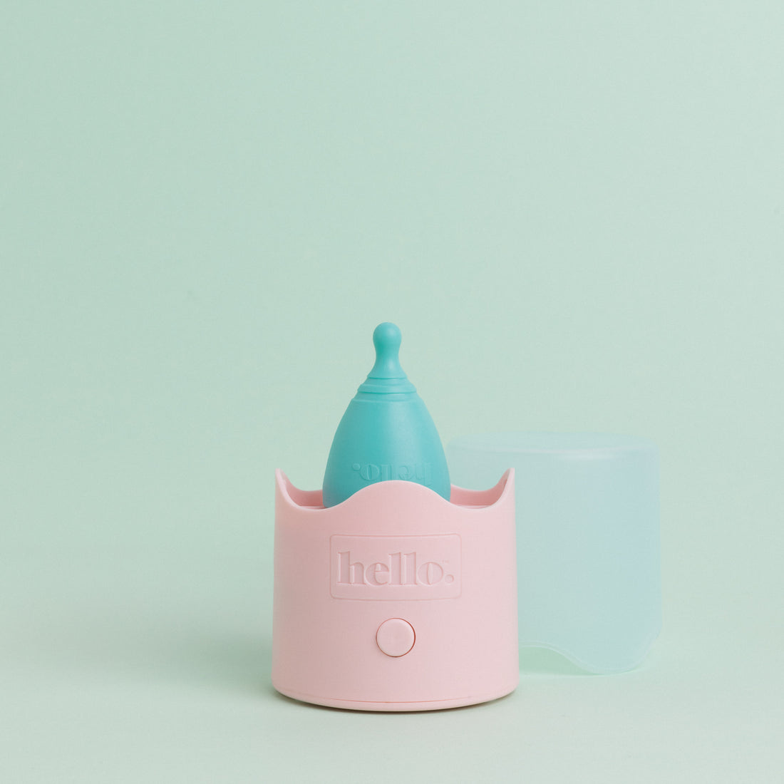 blue hello cup menstrual cup sitting on a pink steam steriliser base against a soft green background