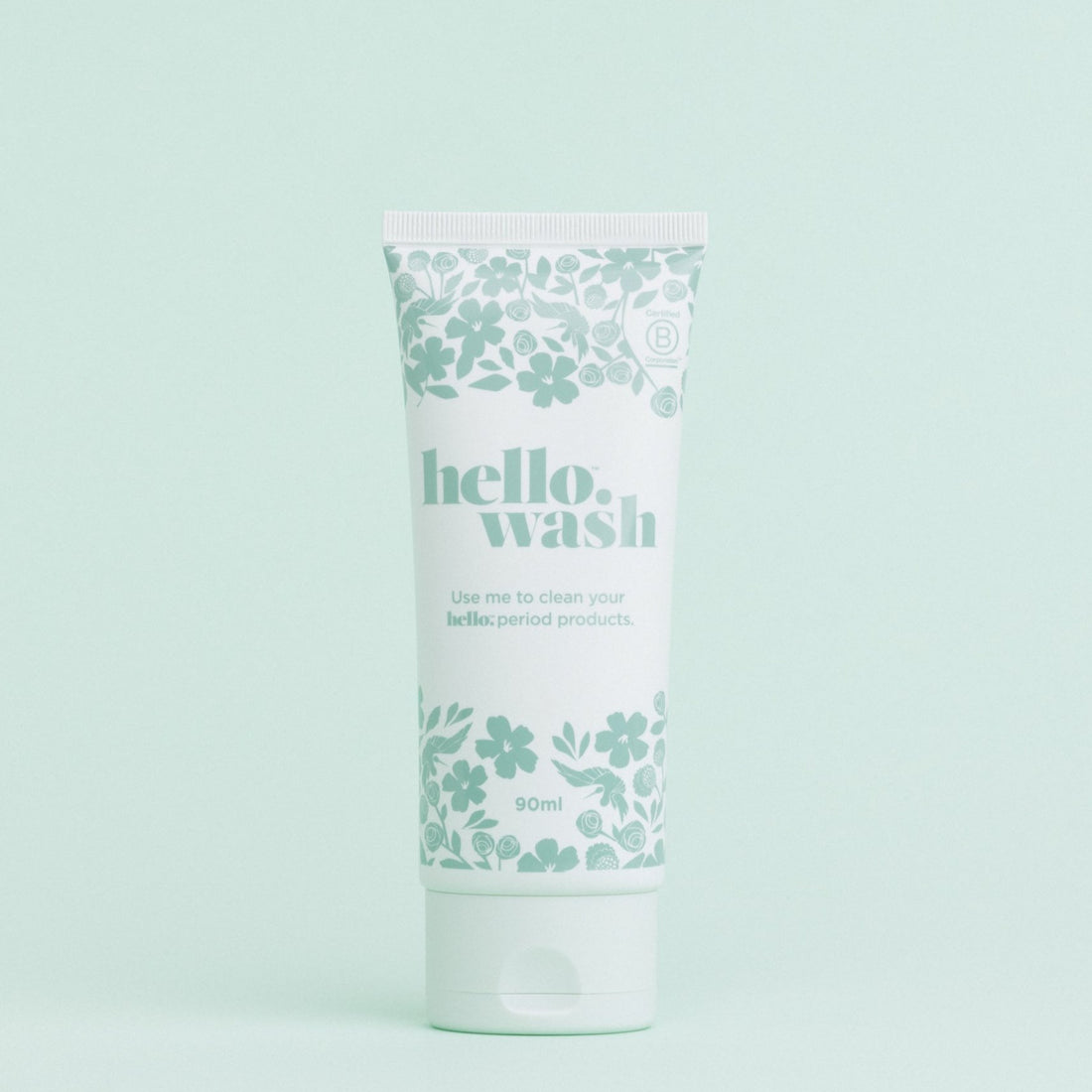 A tube of Hello Wash menstrual cup and menstrual disc cleaner with a floral pattern on a light background.