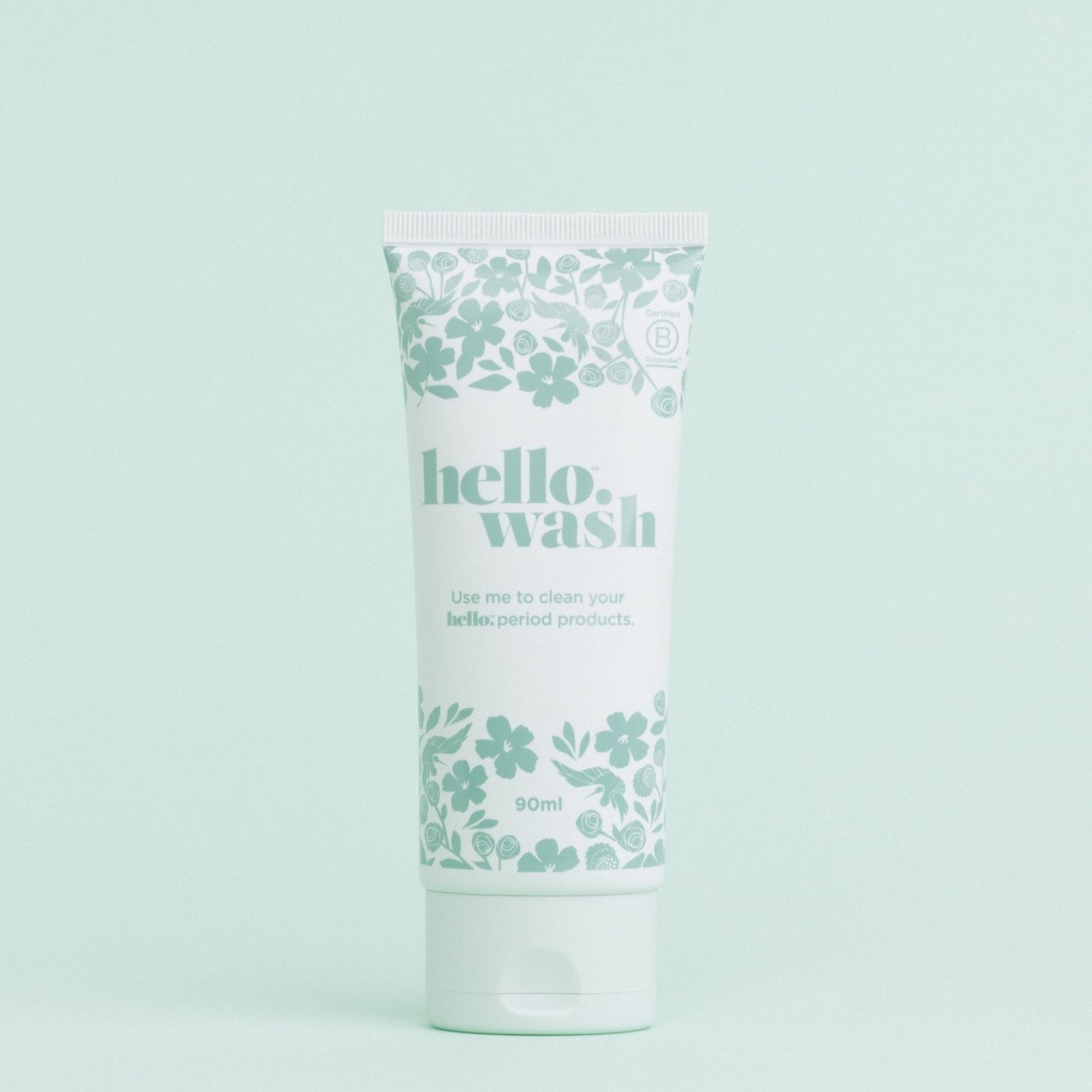A tube of Hello Wash menstrual cup and menstrual disc cleaner with a floral pattern on a light background.