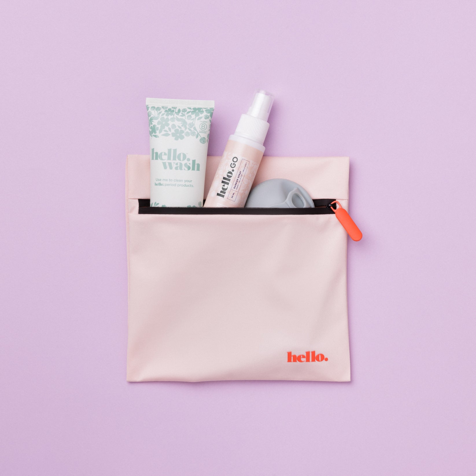 Pink waterproof bag with blue floral tube, small spray bottle and menstrual disc emerging from inside against a lilac backdrop