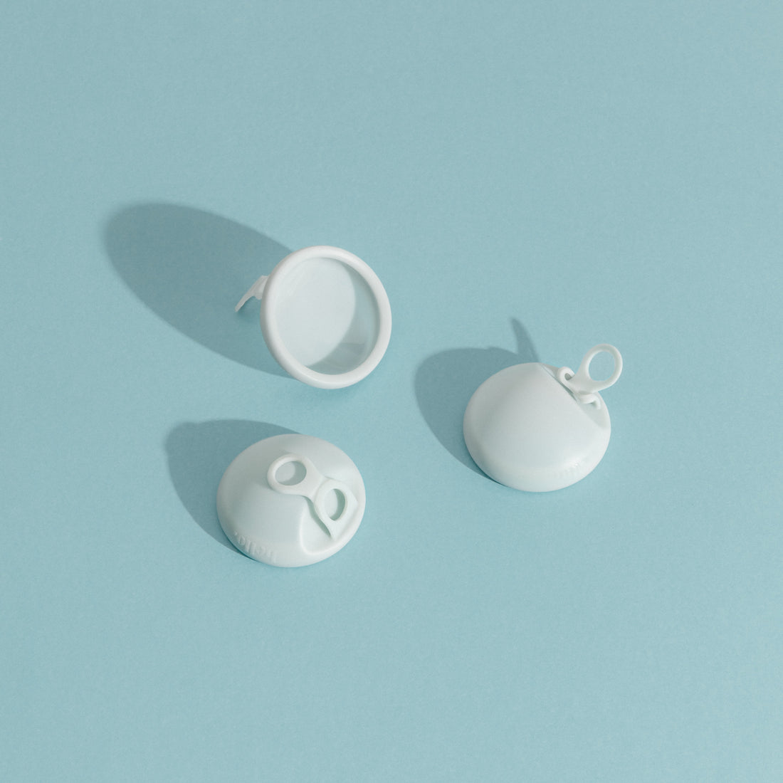 three menstrual discs on a blue background