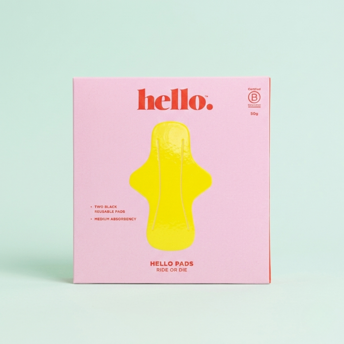 Pink box of Hello Period pads with a yellow pad on a light green background