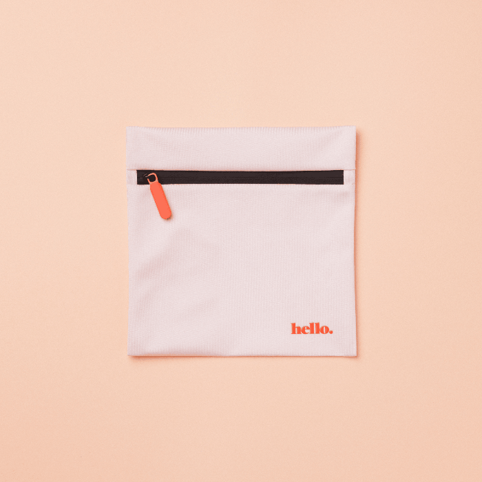A pale pink waterproof storage bag with a black zipper and the word 'hello' printed in red on the front. The bag is displayed against a plain peach background.
